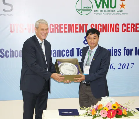 Two delegates hold a commemorative presentation at the agreement signing ceremony.