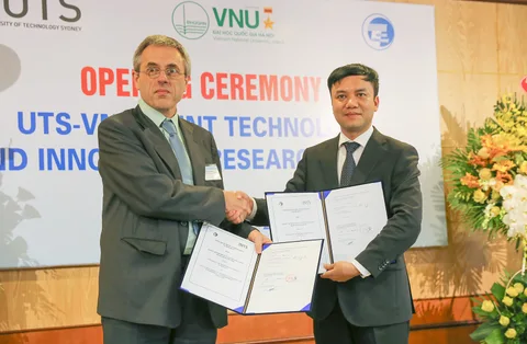 Two delegates display signed documents at the centre opening ceremony.