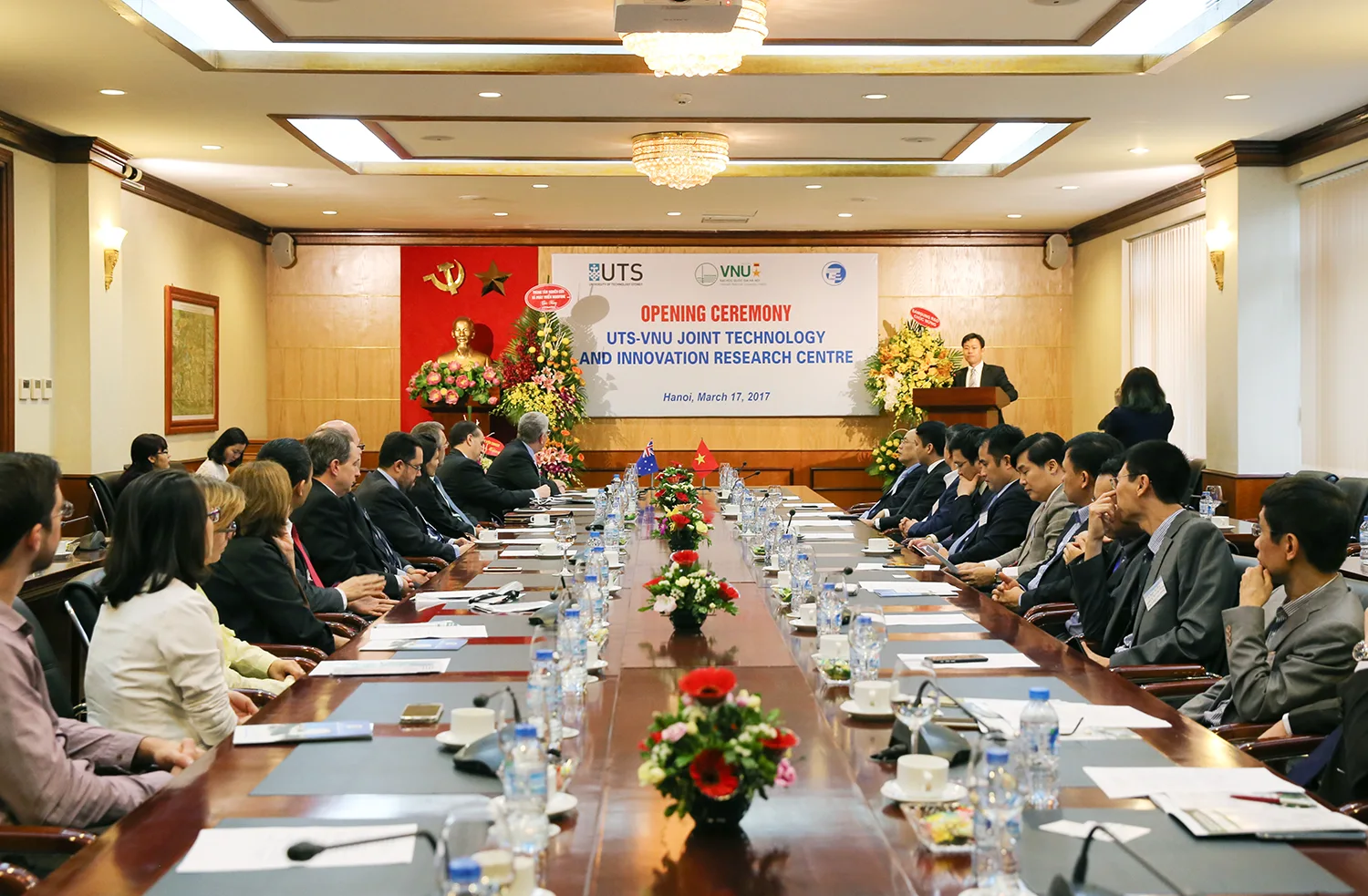 Delegates seated around a long conference table at the centre opening ceremony.