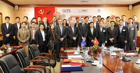 A large group poses in front of the centre opening banner and behind a conference table.